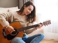 A delightful picture of a young woman smiling and playing guitar. Taken by science teacher Peter Drake of QEHS Hexham
