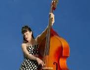 Lovely photo of a woman playing double bass against a blue background. Peter Drake a science teacher from QEHS Hexham took the photo